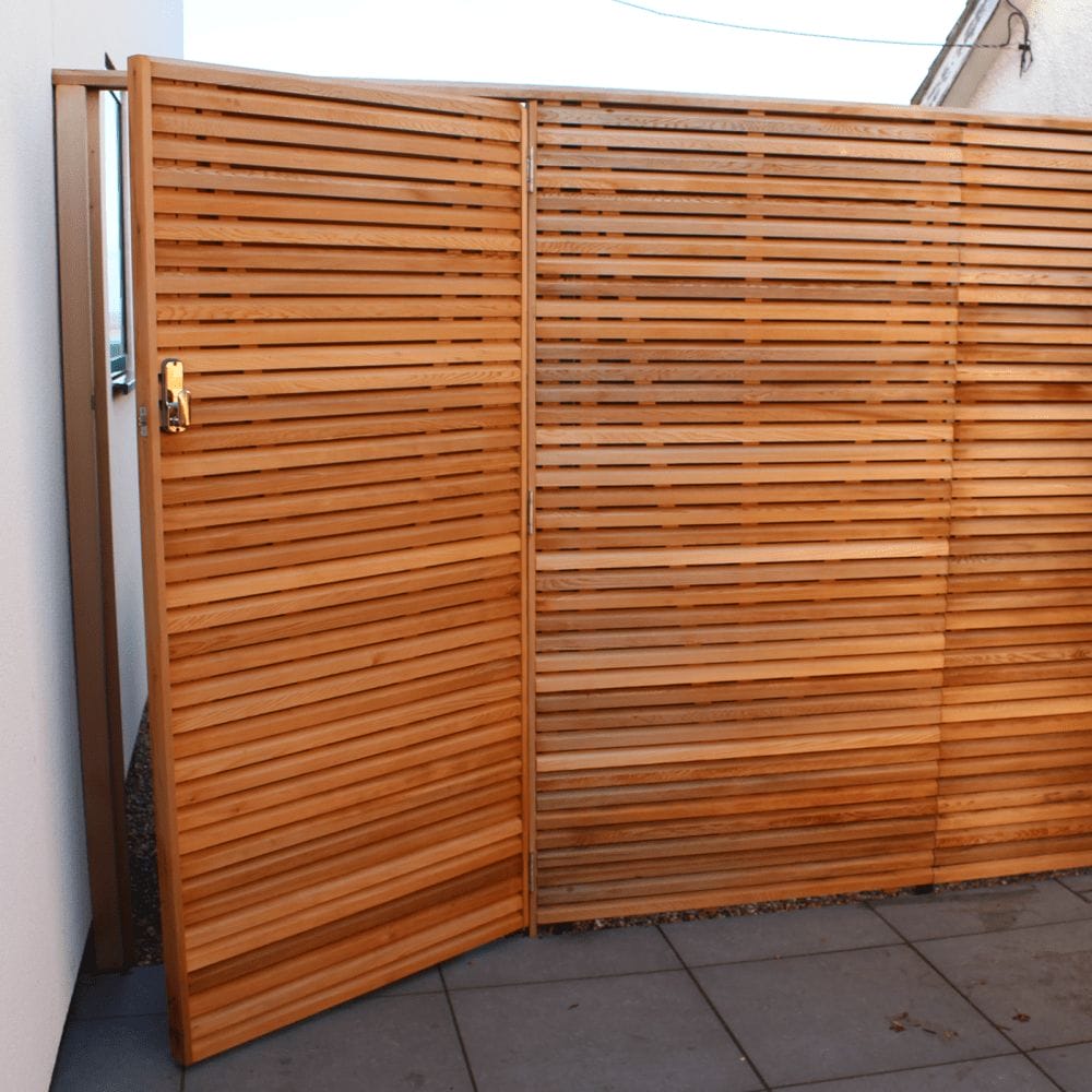 An unlocked Canadian Red Cedar gate matches with the Cedar fence.