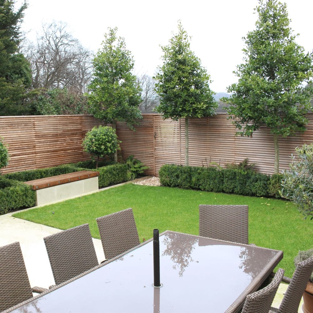 A garden with contemporary Red Cedar fencing and a matching double sided cedar gate.